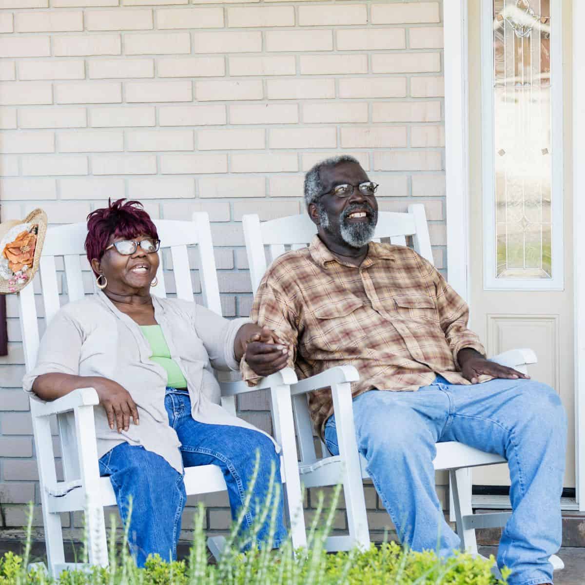 Older African American couple smiling in rocking chairs